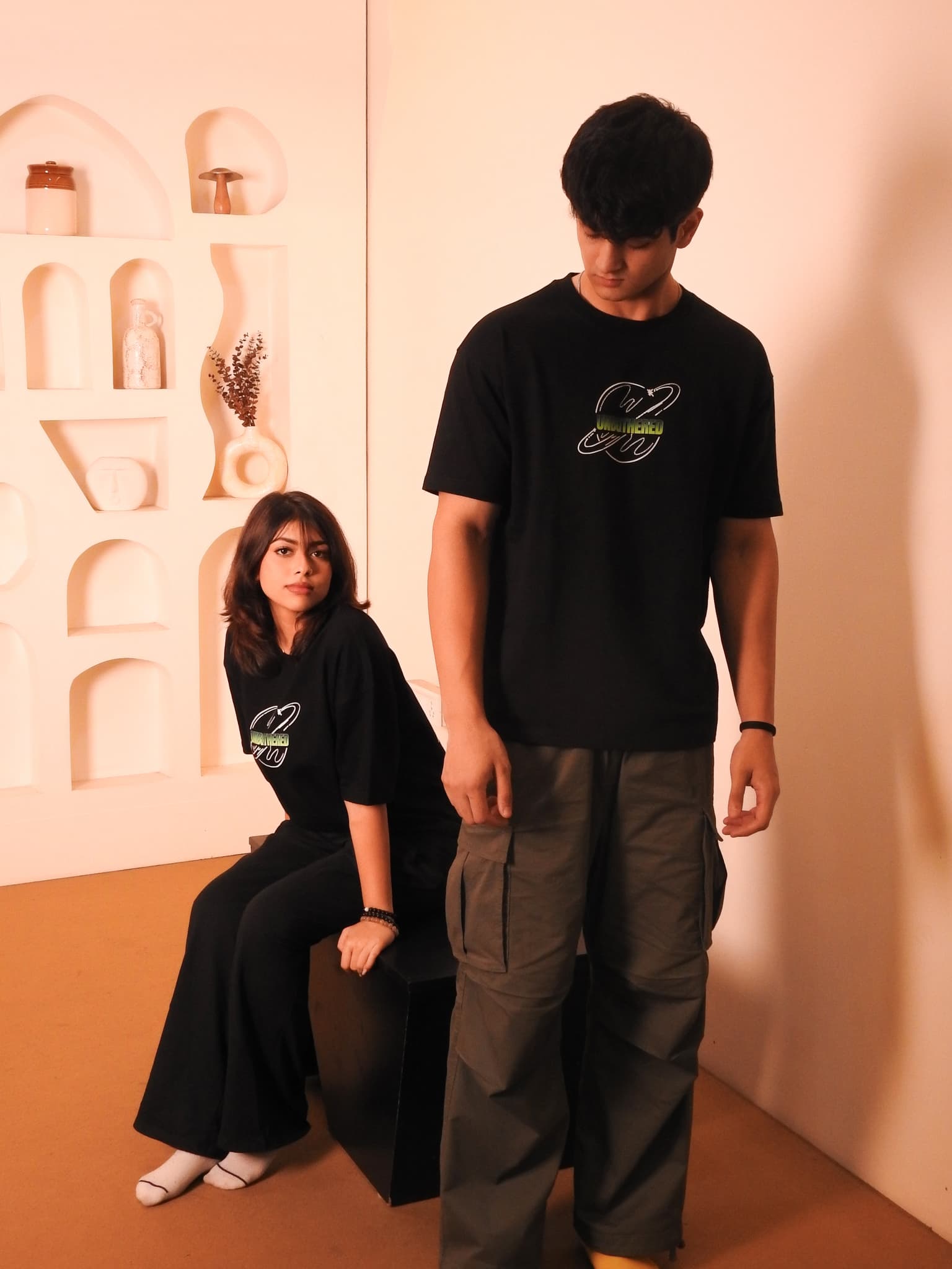 Male and female models in Unbothered tee